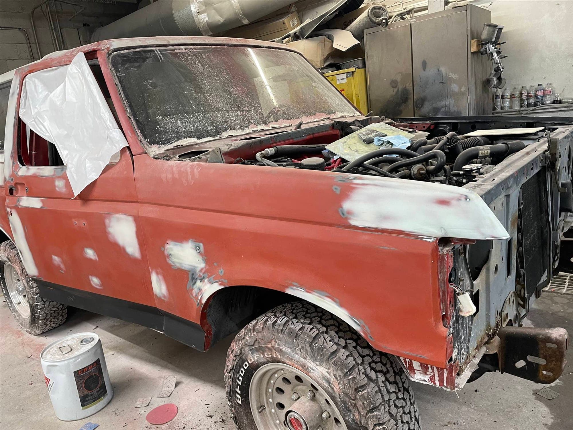 A Ford Bronco in the shop with body filler on the fender, ready for paint